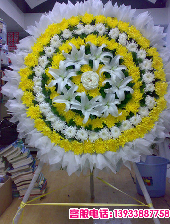 外层黄色菊花，中间白色菊花，内层黄色菊花，8朵白色百合，1朵白色玫瑰，配叶搭配。